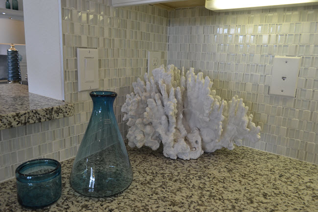 This backsplash combines white glass and stone mosaic.