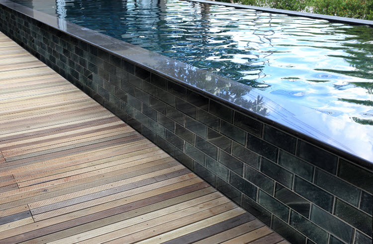 What about dark subway tile? It adds a masculine touch against the black edge of the pool.